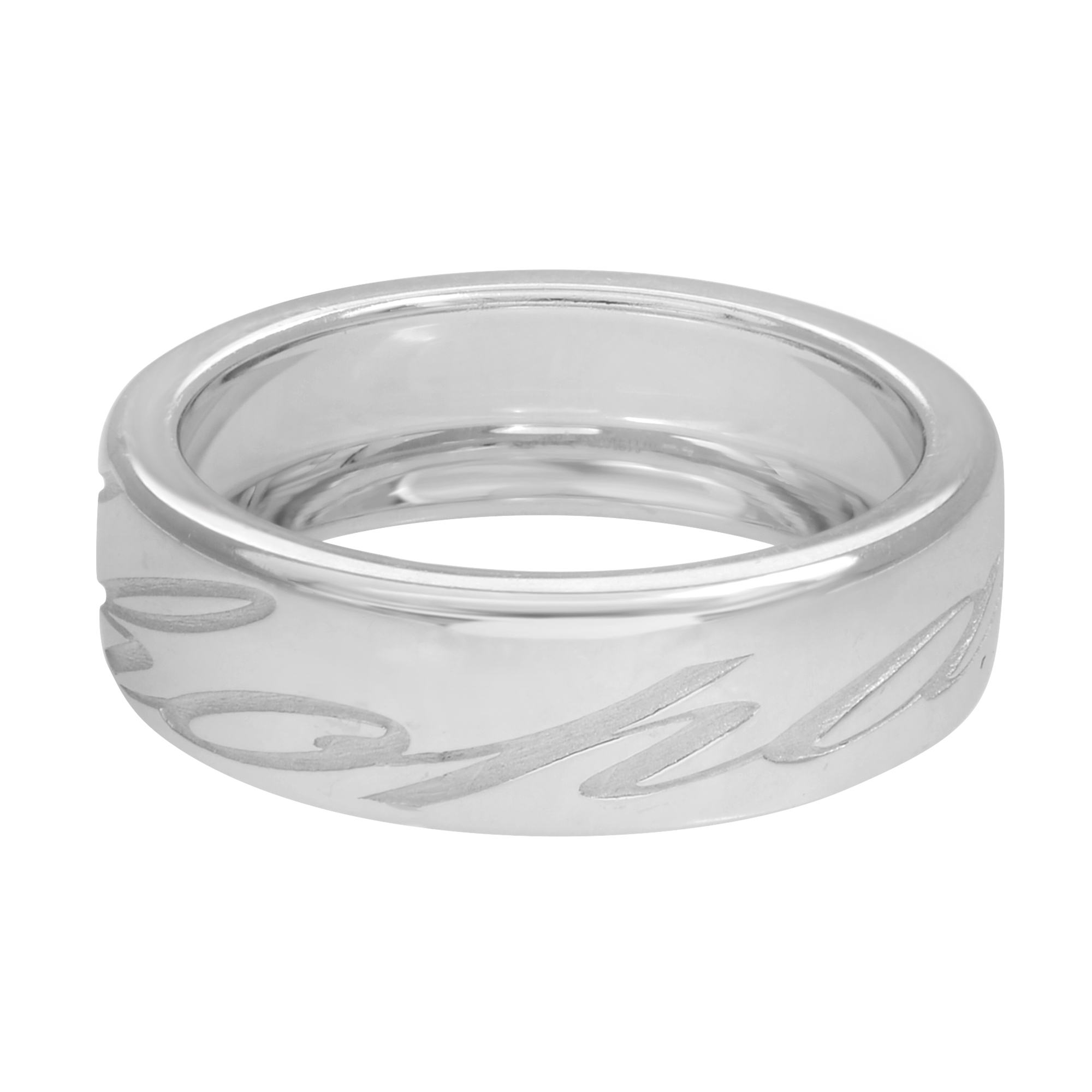 An image of a Chopard women's ring without stones, centered and viewed from a slightly elevated angle showcasing the band's exterior and interior. The polished white gold band features a series of elegantly engraved swirl patterns, with the Chopard brand name visible. The ring is positioned horizontally, occupying the middle of the frame, providing a clear view of its design and craftsmanship. The ring is pre-owned and in great condition.