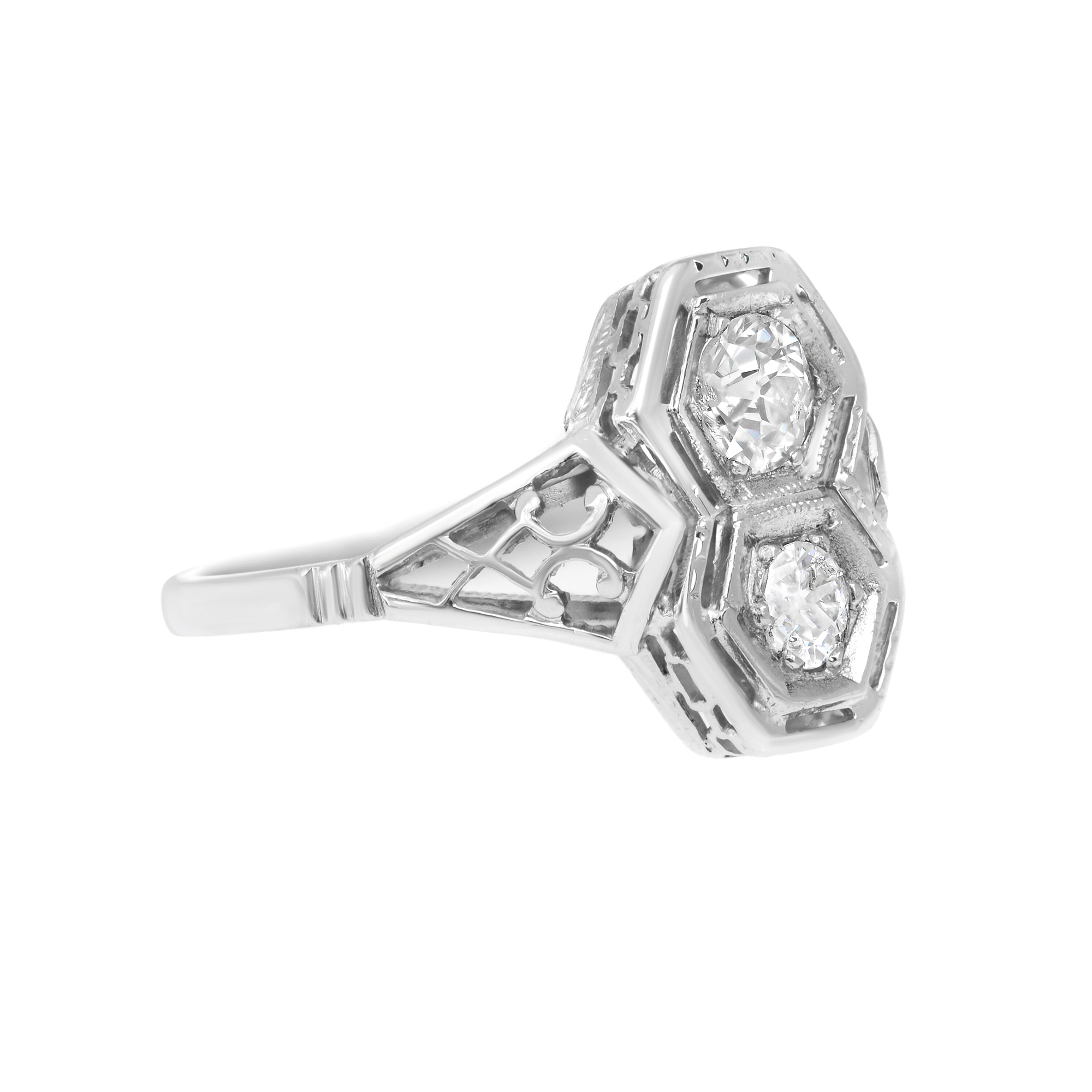An image of a Rachel Koen brand women's vintage ring with diamonds, displayed at a 45-degree angle to showcase the intricate setting and the brilliance of the stones. The ring features a prominent central diamond flanked by two smaller diamonds, all set in a polished white gold band with geometric cut-outs visible from this perspective. The photo is taken from a close distance, with the ring filling the frame, to provide a clear view of the design and craftsmanship.The ring is pre owned in a good condition. 