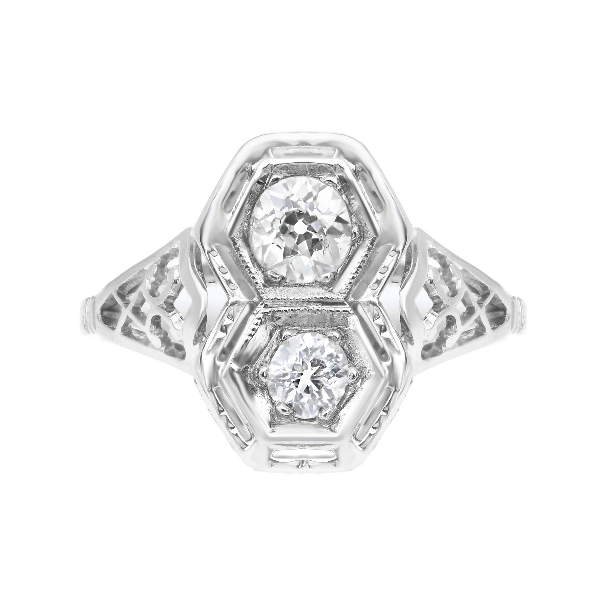 An image of a Rachel Koen women's vintage ring with diamonds, captured head-on from a top view. The ring features a prominent, intricate white gold band with openwork details, leading up to a symmetrical, geometric design at the crown. Two large, round-cut diamonds are set in the center, framed by smaller diamond accents within hexagonal bezels, all displayed against a bright white background that emphasizes the clarity and sparkle of the stones. The shot is taken from a close distance, ensuring the details are crisp and in focus.The ring is pre owned in a good condition. 