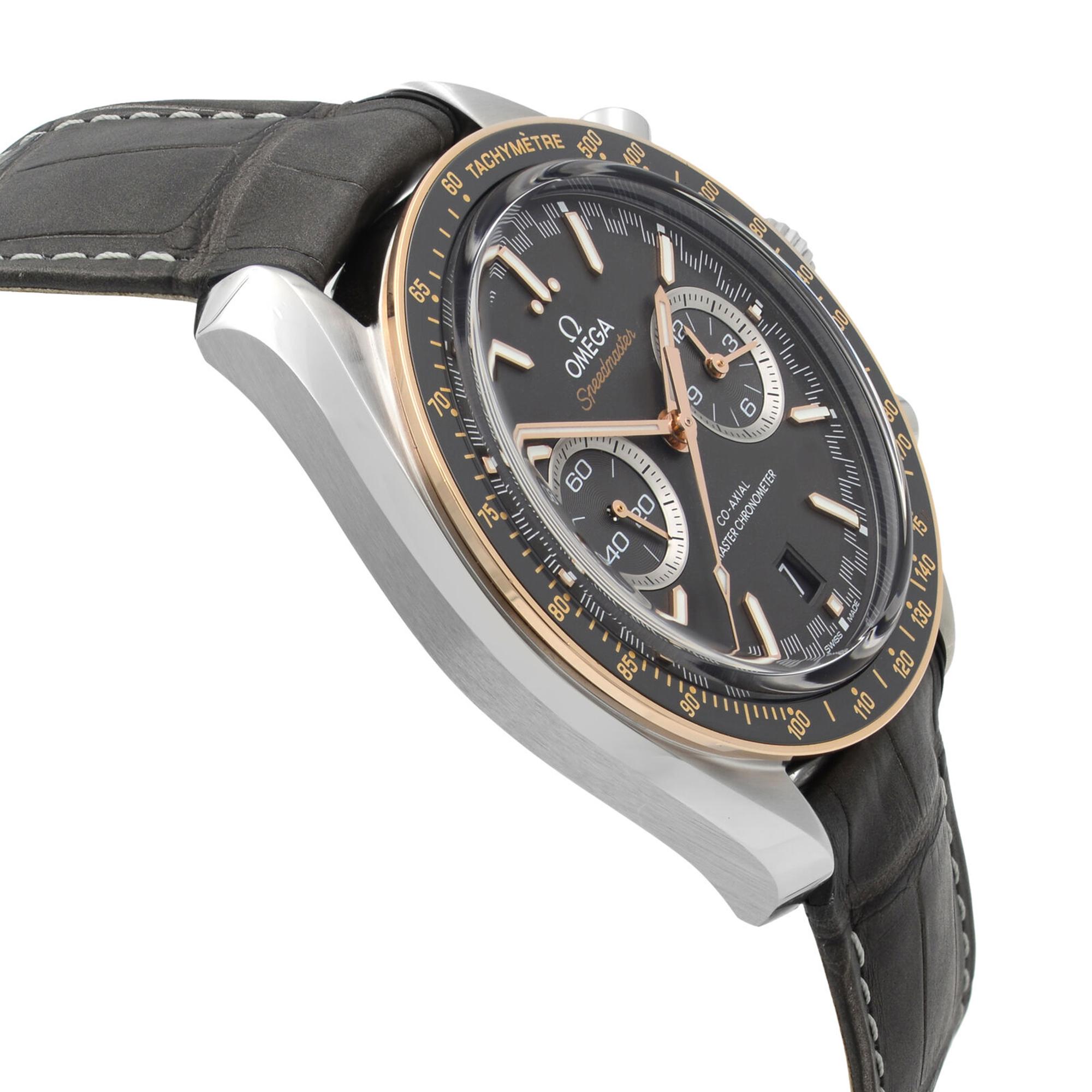 An image of an Omega men's wristwatch taken from a slightly oblique angle, showcasing the watch face and side. The watch features a chronograph and small seconds subdial, with a dark face and rose gold accents. The case is silver steel, and the band is a grey leather with visible stitching. The image is taken at a close distance, emphasizing the details of the watch's design and features.
