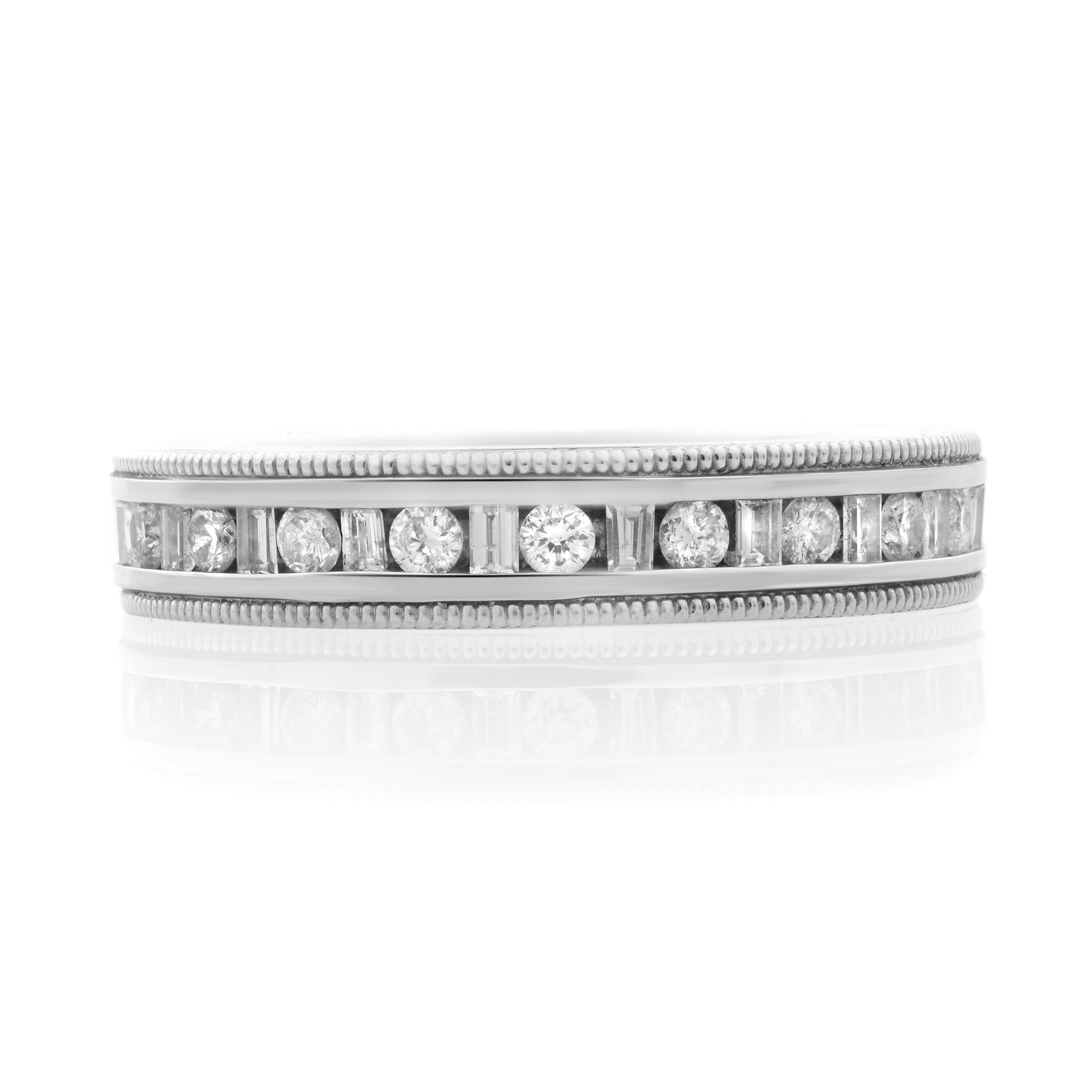 An image of a Rachel Koen women's ring with diamonds, displayed in a frontal view with a close-up angle, showcasing its design in high detail. The ring features a band of alternating larger round-cut diamonds and smaller baguette cut diamonds, all set in a polished silver-toned metal with intricate milgrain edging. The reflection on the surface beneath the ring suggests a shiny, reflective quality.The ring is pre-owned in a great condition. 