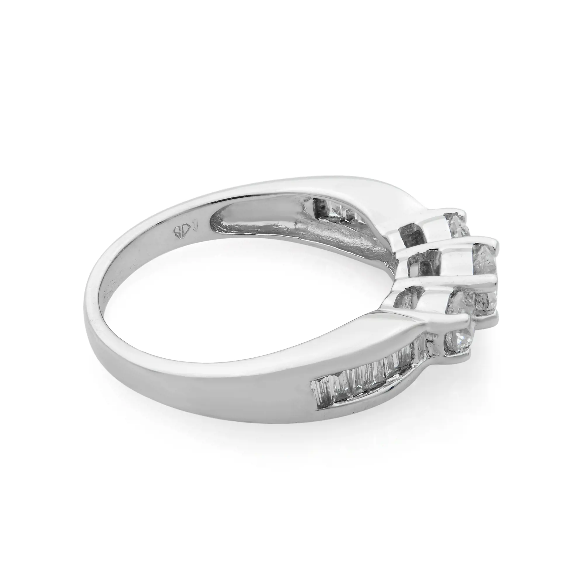 An image of a Rachel Koen women's ring with diamonds, displayed at an oblique angle with the ring's band facing slightly towards the left and the diamond setting angled towards the camera. The ring is positioned in the center against a white background, showcasing its shiny white gold band and the row of inset diamonds along the upper side. The view provides a clear look at the diamonds' cut and the ring's overall design, with moderate distance allowing for detailed observation of the jewelry piece.The ring is pre-owned in a great condition. 