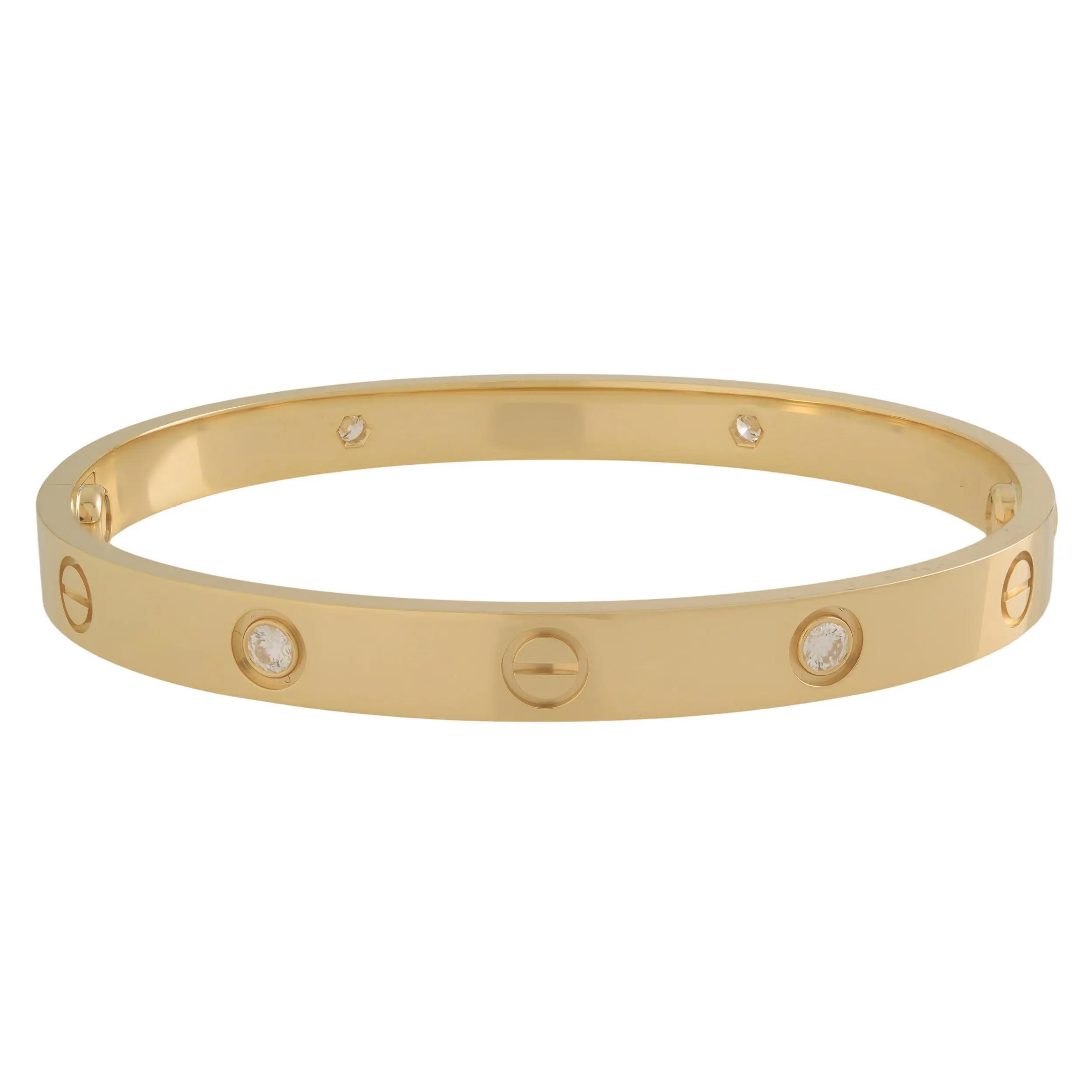 An image of a Cartier love unisex adult bracelet with diamonds, displayed frontally at a close-range perspective. The bracelet is positioned horizontally in the center of the frame, showcasing a polished yellow gold bracelet with evenly spaced screw motifs and diamonds. Embedded within the bracelet are multiple round brilliant-cut diamonds, which catch the light and add a luxurious sparkle to the piece. The view is a neutral angle, neither top-down nor from the side, providing a clear view of the bracelet's design and features. Comes in great preowned condition.