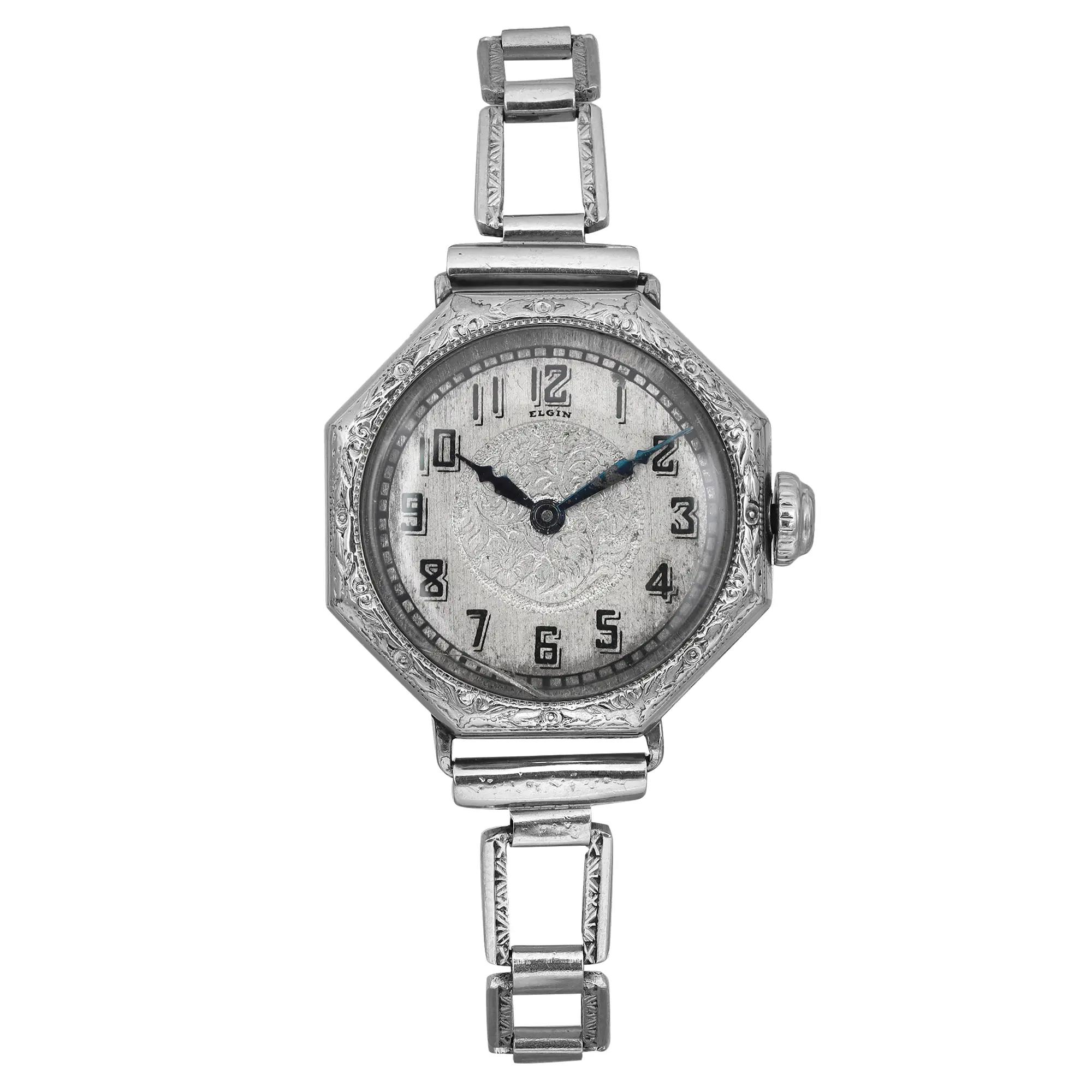 An image of a Wristwatch by Elgin. This Pre Owned item is designed for Women, featuring a Classic style. It has a Mechanical (Manual) movement and an Analog display with a Silver dial color. The indices include 12-Hour Dial,Arabic Numerals. The band is made of steel and the case is made of 14k gold filled. The watch has a Octagonal shape with a case size of 25 mm and a case thickness of 8 mm.