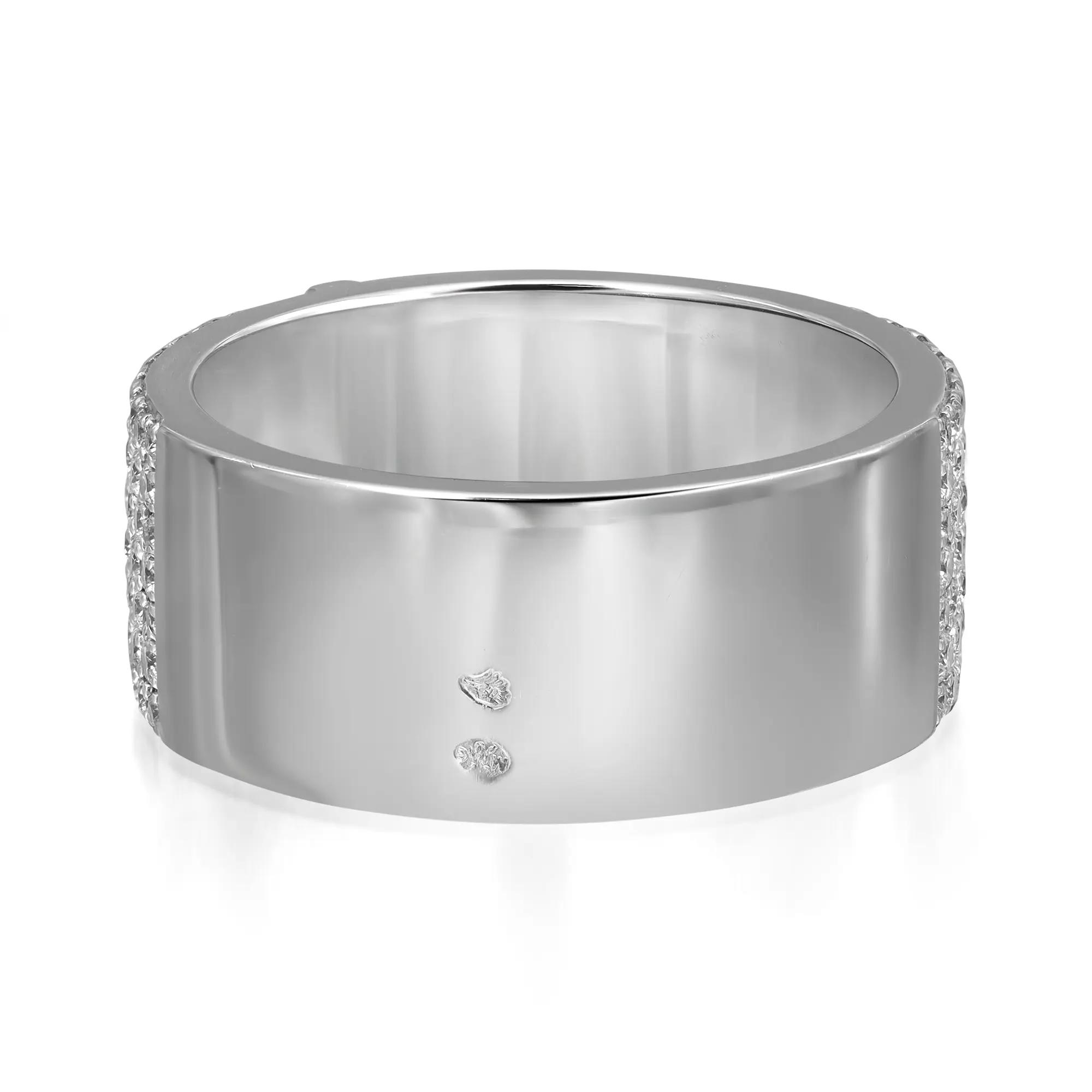 An image of a sleek, silver-colored Messika ring for women, viewed from a slightly elevated angle that highlights its smooth band and the row of small, sparkling diamonds set along its edge. Two larger, round-cut diamonds are visibly embedded on the ring's outer surface, spaced apart, providing a focal point. The ring is centered and shown up-close, capturing its reflective metal surface and the intricate details of the diamond setting.