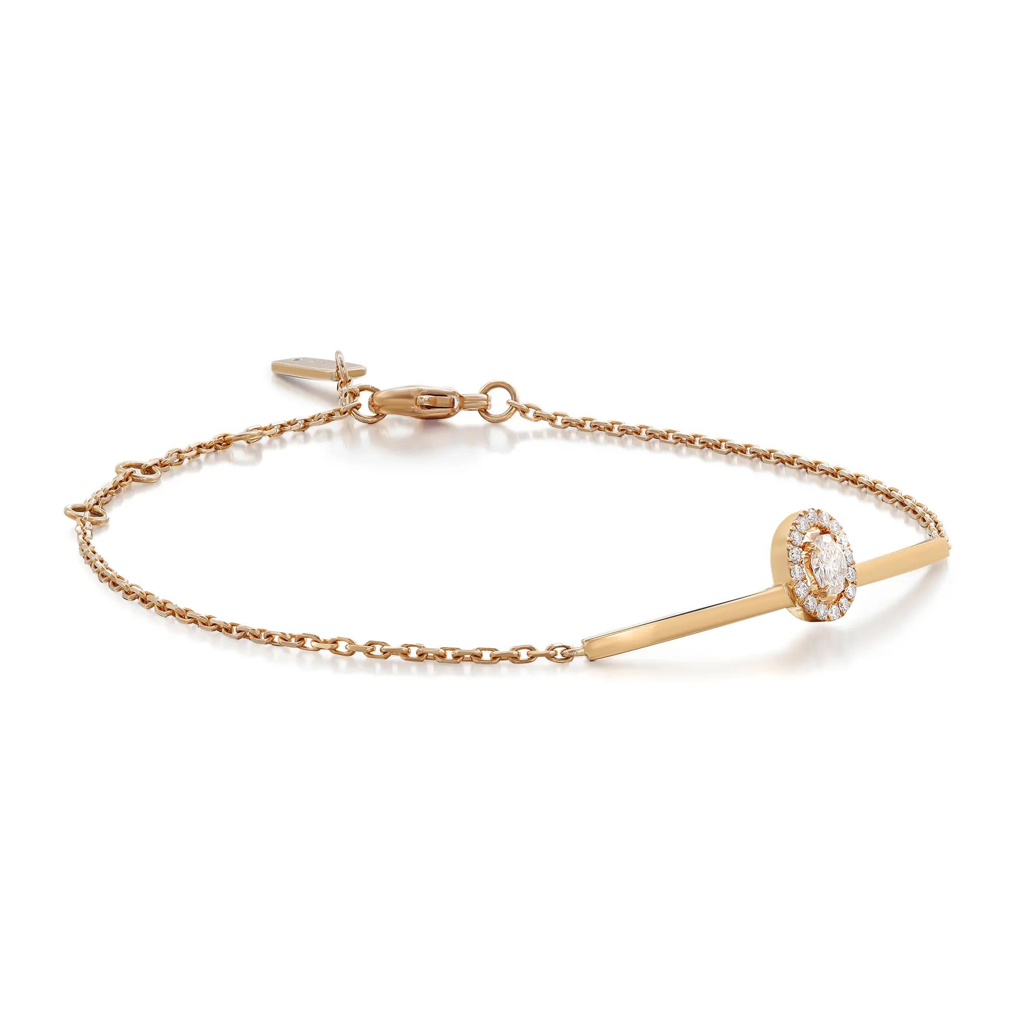 An image of a Messika women's bracelet with diamonds, displayed on a white background. The bracelet features a delicate gold chain with a central bar design, angled slightly to the left, with a halo of small diamonds encircling a larger central diamond at the far end. The bracelet is positioned horizontally across the frame with the clasp visible on the left side and the diamond-encrusted feature closer to the right side, providing a clear view of the bracelet's design. The image is taken from a top-down perspective at close range, ensuring the intricate details are visible.