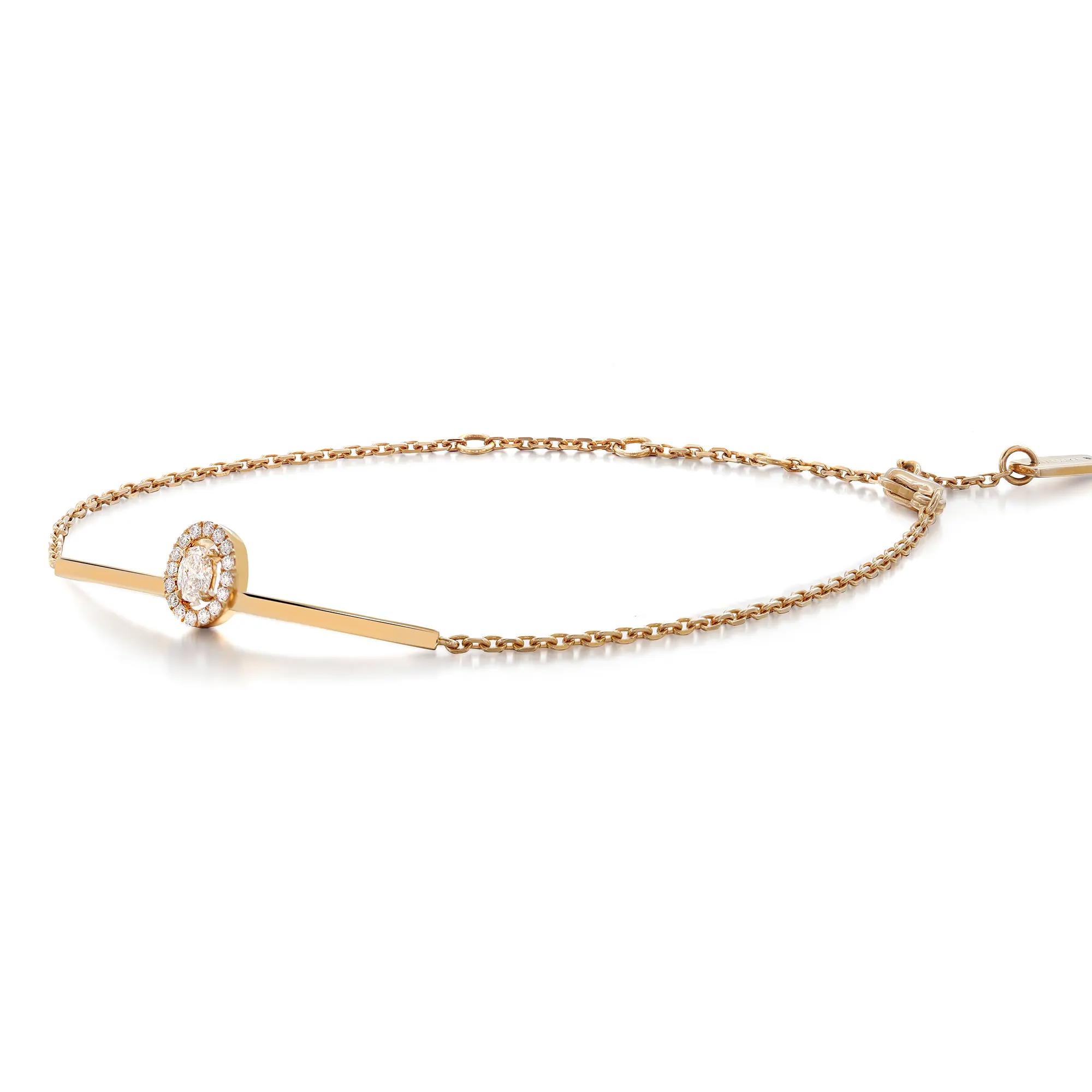 An image of a Messika women's bracelet with diamonds, displayed against a white background. The bracelet is arranged horizontally across the center of the frame, showcasing a delicate rose gold chain with a diamond-encrusted circular charm near the left side. The piece is viewed at a slight angle from above, offering a clear view of the diamonds' arrangement and the bracelet's intricate design. The image is taken from a close distance, emphasizing the jewelry's elegance and craftsmanship.
