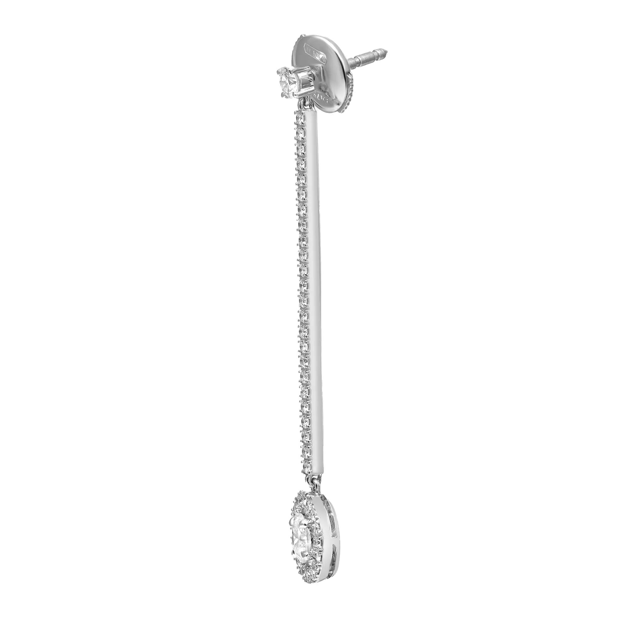 An image of a Messika brand earring designed for women, featuring a vertical alignment of diamonds set in a linear drop style. The earring is displayed against a white background at a close distance and a straight-on angle, providing a clear view of the intricate diamond settings and the overall elegance of the piece.