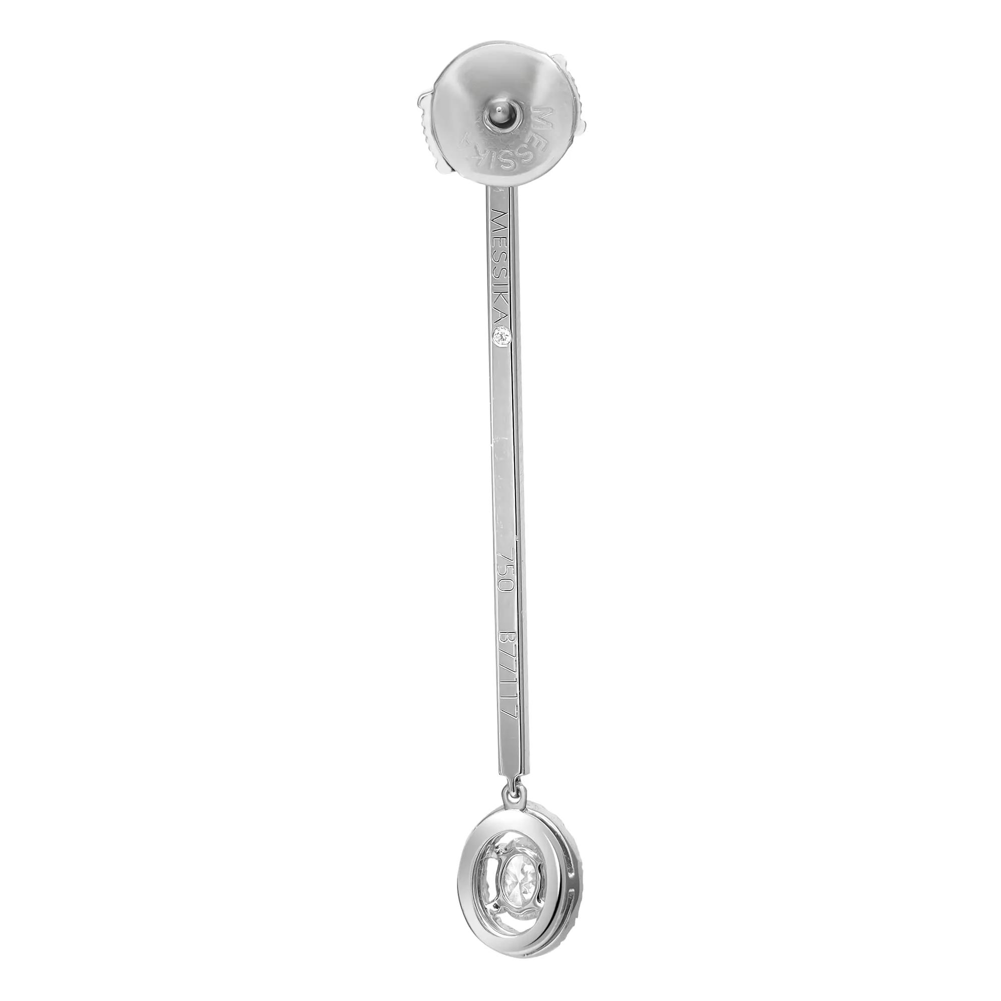 An image of a Messika women's earring with diamonds, displayed against a white background. The earring is captured in a front-facing view, showcasing its design with clarity and detail. The earring post is at the top with "MESSIKA" engraved along the vertical bar leading to a circular diamond-encrusted pendant at the bottom. The photograph is taken from a medium distance, allowing for the entire length of the earring to be visible, and it is positioned directly in the center of the frame, facilitating an unobstructed view of its features.