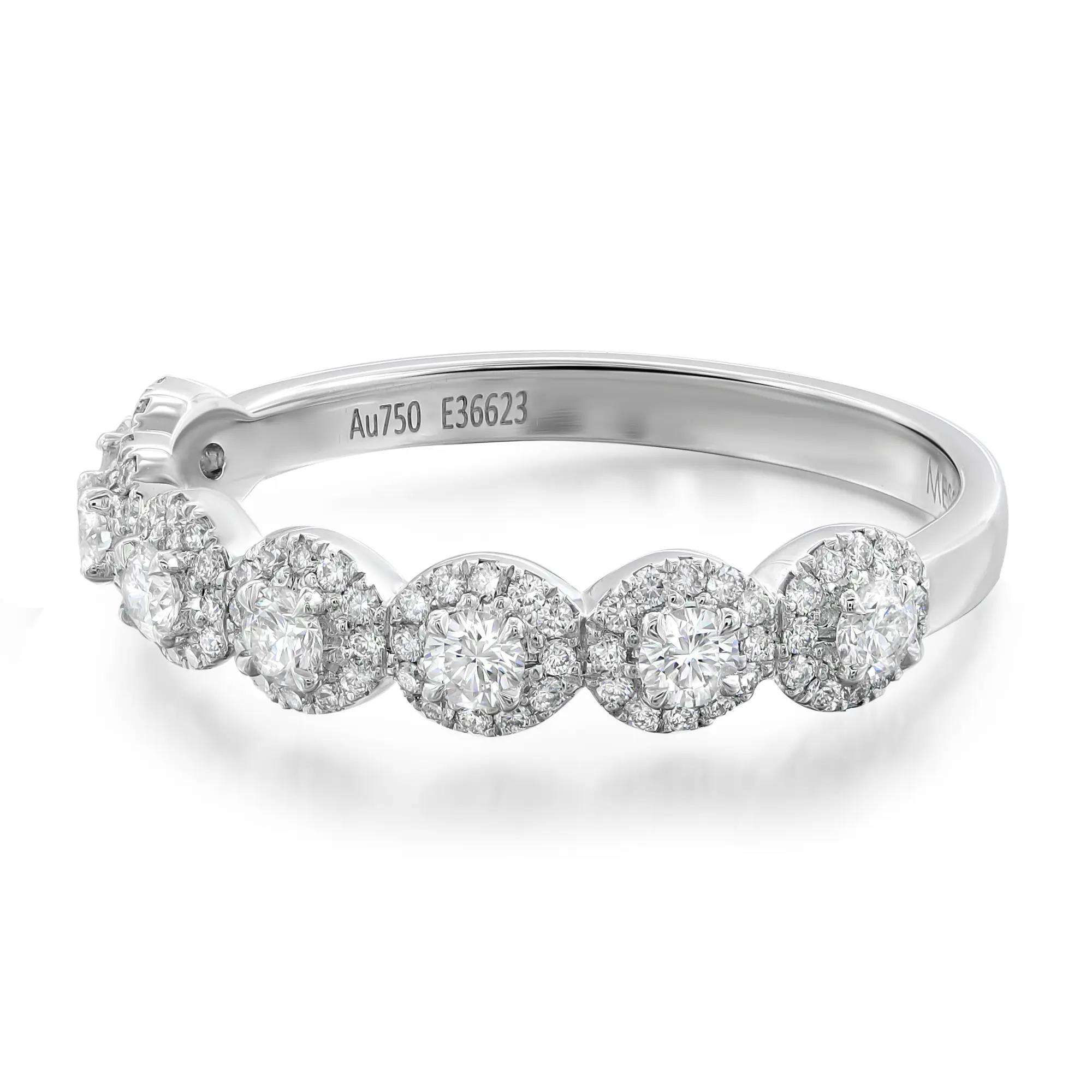 An image of a women's Messika ring with diamonds, presented on a white background. The ring is displayed at a slight angle, allowing a view of the top and side of the band. The band is made of polished white gold, stamped with "Au750" indicating 18k gold, and a unique serial number "E36623". It features a sequence of five circular settings along the top, each holding a central diamond surrounded by smaller pavé diamonds, creating a sparkling chain effect. The craftsmanship is visible with a clear view of the prongs and the intricate setting of the stones. The image is taken from a medium distance, showcasing the ring in full with a focus on the detailed work and brilliance of the diamonds.