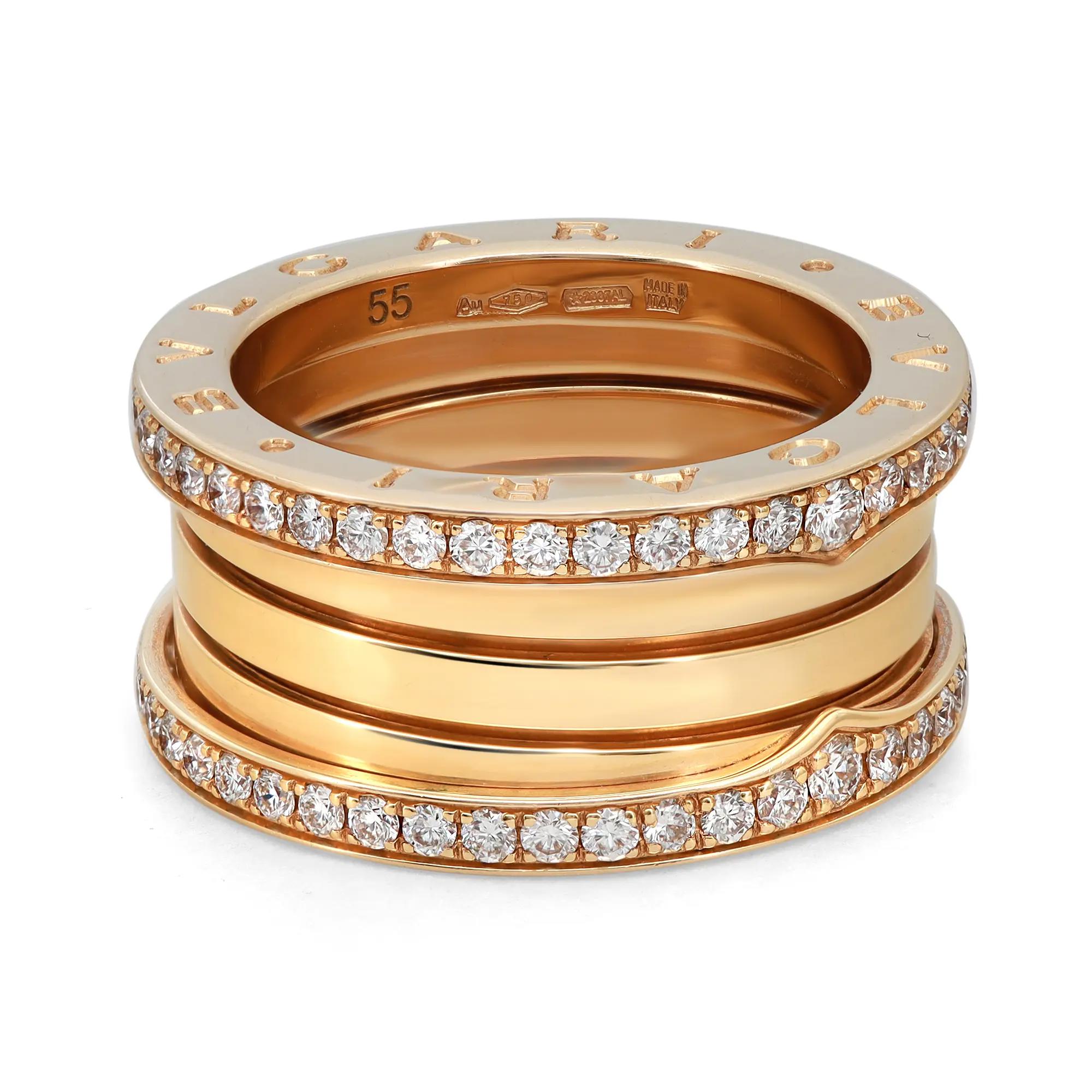 An image of a Bvlgari B.Zero1 unisex adult ring with diamonds, showcased from a top-down perspective at a slight angle. The ring features multiple bands of polished yellow gold, with two of the bands encrusted with round-cut diamonds. The product is photographed up close on a white background, allowing for clear visibility of the intricate details, including the engraved brand name and size inside the band. The condition of the ring is new. 