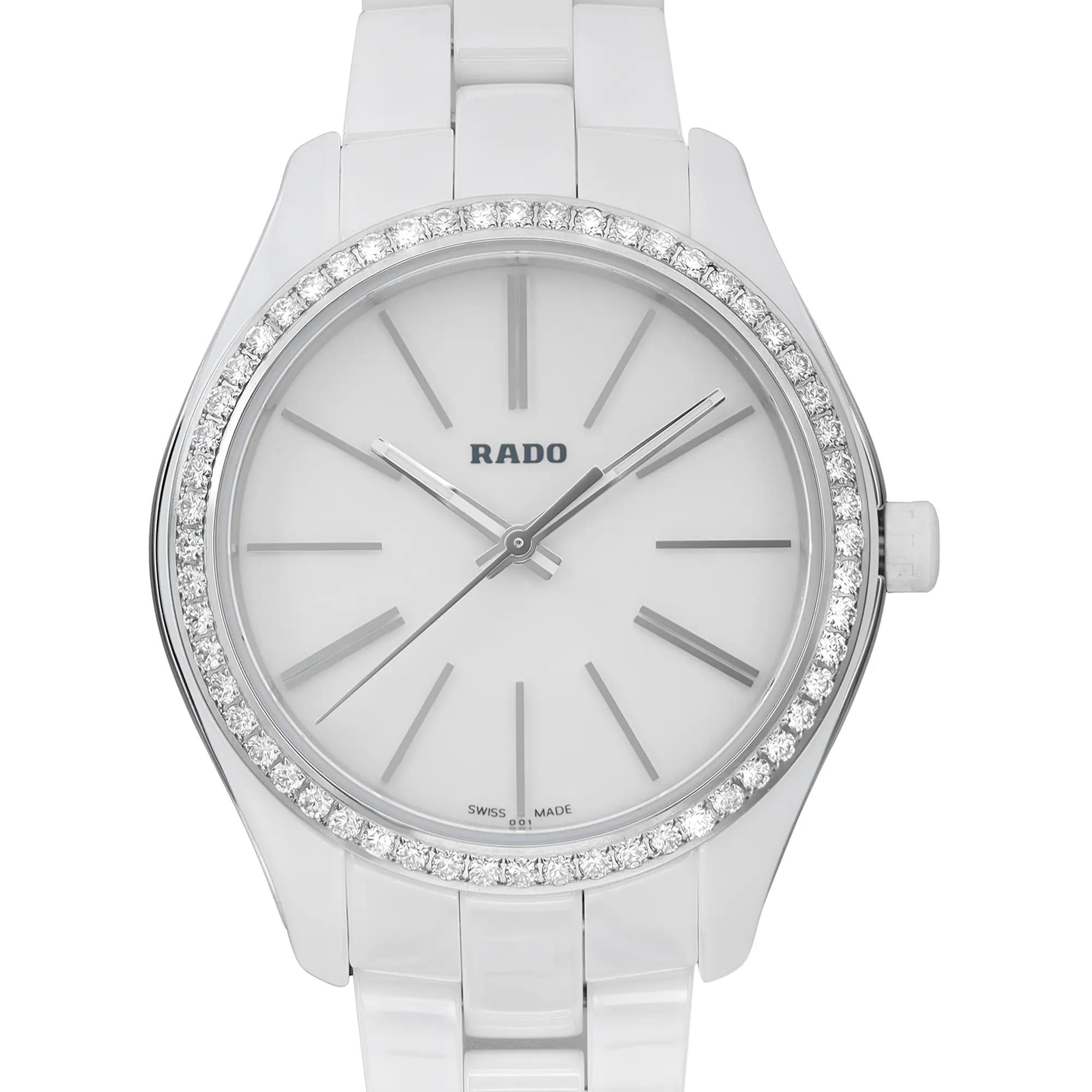 An image of an unworn women's Rado wristwatch in a casual style, captured in a front close-up shot showcasing the watch face. The watch features a round white dial with non-numeric hour marks and stick indexes, as well as a seconds hand and luminous hands. The gray bezel is adorned with diamonds, and the band is made of white ceramic. The case material combines ceramic and stainless steel, reflecting excellent condition. The watch is positioned head-on at a close distance, providing a clear view of the brand name and the details of the watch face.