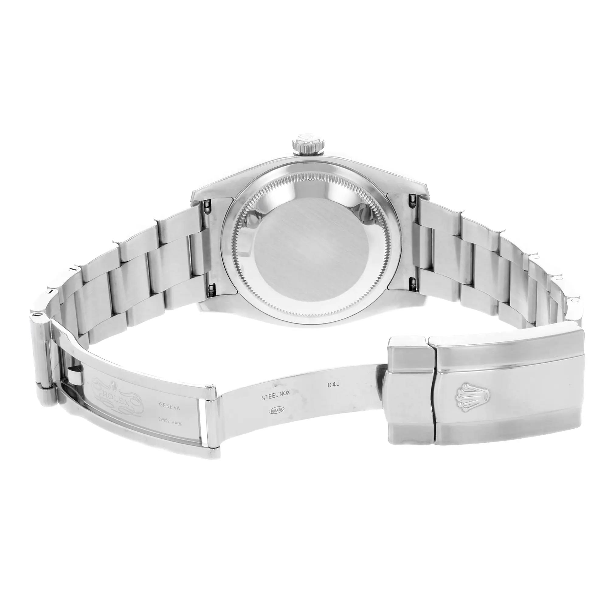 An image of a pre-owned wristwatch taken from the back view, showcasing the open clasp. The angle captures the watch from a slightly elevated perspective, highlighting the smooth, metallic finish of the bracelet links and the case back. The image is taken at a close distance, emphasizing the intricate details and engravings on the clasp.