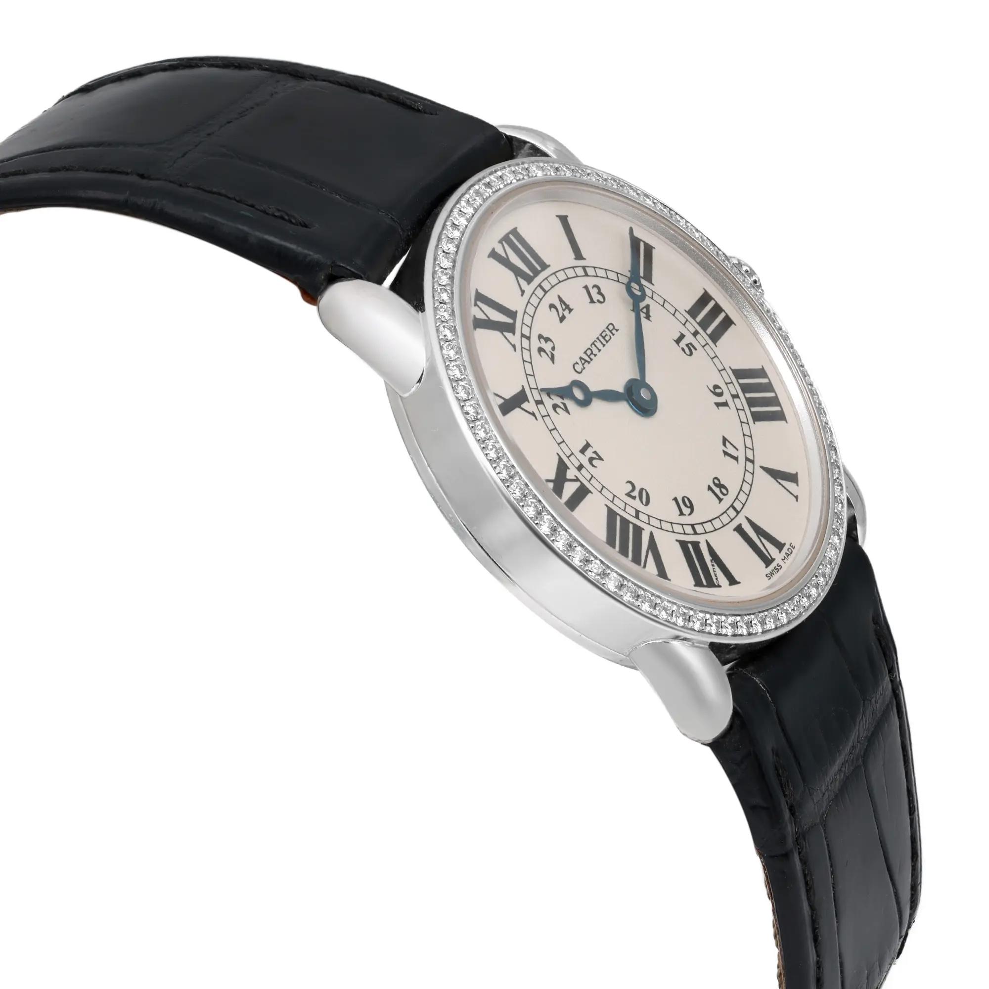 An image of a pre-owned wristwatch viewed from the side profile, opposite the crown. The watch features a round silver case with a diamond-studded bezel and a classic white dial with Roman numerals. The angle is slightly elevated, capturing the watch at a medium distance, showcasing its elegant black leather strap.