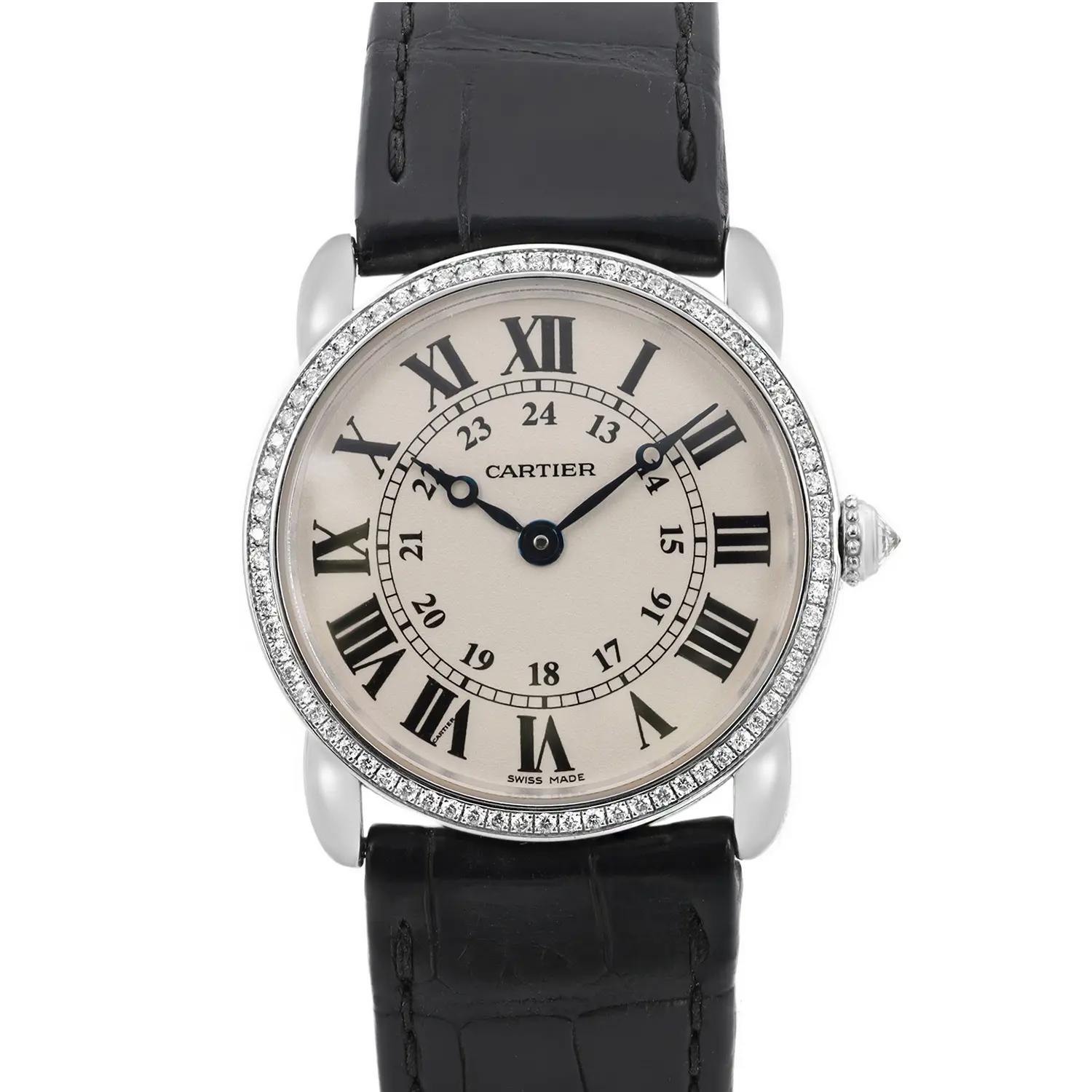 An image of a pre-owned wristwatch taken from a front close-up angle. The watch features a round face with black Roman numerals and a silver bezel adorned with small crystals. The timepiece has a black leather strap with visible stitching. The brand name is visible on the watch face.