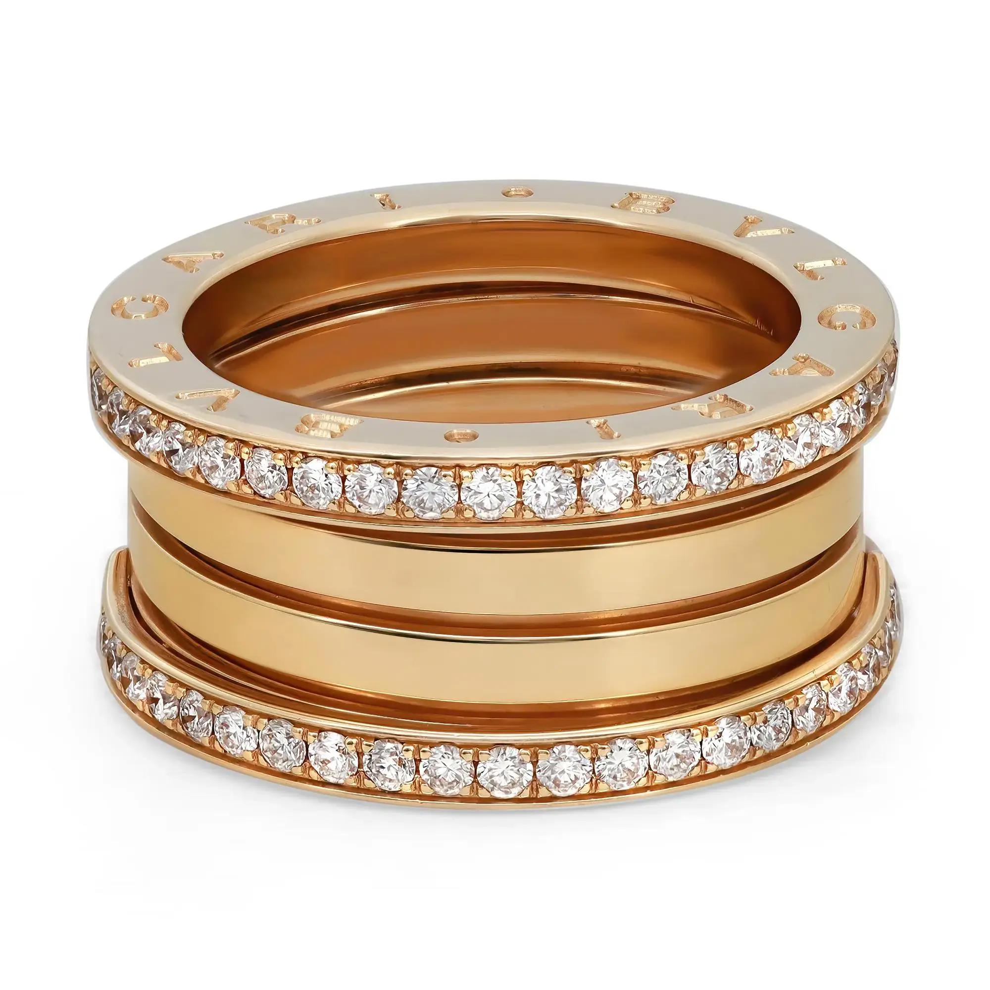 An image of a Bvlgari B.Zero1 unisex adult ring with diamonds, displayed at a close-up angle. The ring features multiple gold bands stacked closely together, with two bands encrusted with sparkling diamonds in a channel setting. The piece is photographed against a white background, with the ring oriented horizontally in the center of the frame. The view is from slightly above the ring, showcasing the intricate design and the diamonds' brilliance.The condition of the ring is new. 